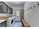Well-appointed laundry room features a bench with hooks, washer, dryer and custom cabinetry at 7920 Tintern Trce, Duluth, GA 30097