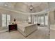 Main bedroom featuring a tray ceiling, modern lighting, and large windows with shutters at 7920 Tintern Trce, Duluth, GA 30097