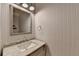 Chic powder room featuring wallpaper, sleek fixtures and a marble countertop at 7920 Tintern Trce, Duluth, GA 30097