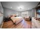 Cozy bedroom featuring a comfortable bed, elegant lighting, and beautiful hardwood floors at 149 Avalon Way, Sharpsburg, GA 30277