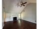 Inviting living room featuring dark wood floors, a cozy fireplace, and a vaulted ceiling with fan at 160 Goldleaf Dr, Hampton, GA 30228