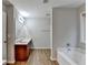Well-lit bathroom with a vanity, large mirror, soaking tub and neutral color palette at 2842 Sedgeview Ln, Buford, GA 30519