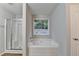 Bathroom featuring a separate shower, soaking tub, and large window at 2842 Sedgeview Ln, Buford, GA 30519