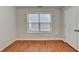 Bedroom featuring wood-look floors, neutral walls, a window and white door at 2842 Sedgeview Ln, Buford, GA 30519