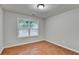 Cozy bedroom with wood-look floors, neutral paint, and a window bringing in natural light at 2842 Sedgeview Ln, Buford, GA 30519