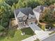 An aerial shot of the two-story brick home with a two-car garage, neatly landscaped front yard, and fenced backyard at 3865 Brookhollow Dr, Douglasville, GA 30135