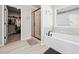 Bright bathroom with a tiled shower, soaking tub, neutral colors, and access to a closet at 3865 Brookhollow Dr, Douglasville, GA 30135