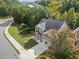 Aerial view of a brick home with a two-car garage, surrounded by lush greenery and a well-maintained lawn at 3865 Brookhollow Dr, Douglasville, GA 30135