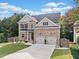 Charming two-story brick home with a well-manicured lawn, two-car garage and beautiful landscaping at 3865 Brookhollow Dr, Douglasville, GA 30135