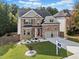 Inviting two-story brick home featuring a spacious lawn, a two-car garage, and a welcoming front entrance at 3865 Brookhollow Dr, Douglasville, GA 30135