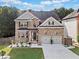 Charming two-story brick home with a well-manicured lawn, two-car garage, and lovely curb appeal at 3865 Brookhollow Dr, Douglasville, GA 30135