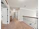 Bright upstairs hallway with neutral walls, dark banister, and access to rooms at 3865 Brookhollow Dr, Douglasville, GA 30135