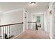 Carpeted hallway featuring dark banister, with multiple doors and a view to lower level at 3865 Brookhollow Dr, Douglasville, GA 30135