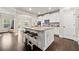 Open-concept kitchen with a granite island, white cabinets, stainless steel appliances, and a view to the dining area at 3865 Brookhollow Dr, Douglasville, GA 30135