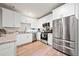 Bright kitchen featuring stainless steel appliances, white cabinets, granite counters, and wood-look flooring at 3865 Brookhollow Dr, Douglasville, GA 30135