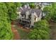 Aerial view of the home's backyard with a deck, screened in porch, and mature trees at 414 Silver Top Dr, Grayson, GA 30017