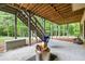 Back patio with hanging swing, fire pit, stairs to deck, and wooded scenery beyond at 414 Silver Top Dr, Grayson, GA 30017