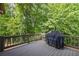 Wooden deck with a grill and views of a lush, green backyard with mature trees at 414 Silver Top Dr, Grayson, GA 30017
