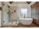 This bathroom features a glass shower, free standing tub, wood floors, and barn door adding rustic charm at 414 Silver Top Dr, Grayson, GA 30017