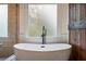 Relax in this bathroom with a free standing tub, glass shower and sliding barn door for a rustic retreat at 414 Silver Top Dr, Grayson, GA 30017