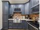 Close-up of kitchen details including stainless steel sink, wine rack, exposed brick, and stylish cabinetry at 414 Silver Top Dr, Grayson, GA 30017
