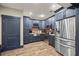 Charming kitchen boasts stainless appliances, stone counters, brick backsplash, and stylish blue cabinetry at 414 Silver Top Dr, Grayson, GA 30017