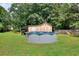 Backyard featuring an above-ground pool, storage shed, and playset on a lush lawn at 1050 Kirkland Rd, Covington, GA 30016
