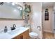 Bathroom features a wood vanity with shelves, mirror, and a white toilet at 1050 Kirkland Rd, Covington, GA 30016