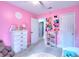 Bright pink bedroom with white furniture, including a dresser, shelving, and a small bed at 1050 Kirkland Rd, Covington, GA 30016