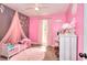 Pink-themed bedroom featuring a single bed, vanity, canopy and plenty of natural light at 1050 Kirkland Rd, Covington, GA 30016