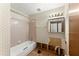 Bathroom featuring a tub/shower combination, tile walls, and a damaged floor at 4949 Woodland Nw Way, Acworth, GA 30102