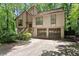 Two-story home with wood siding, two-car garage, stairs leading to front door, and mature trees at 4949 Woodland Nw Way, Acworth, GA 30102