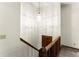 Hallway showcasing wood railing, a hanging light, and a wooden door at 4949 Woodland Nw Way, Acworth, GA 30102