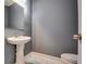 Elegant half bathroom with pedestal sink and marble tile floor at 6269 Colonial Vw, Fairburn, GA 30213