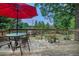 Outdoor deck featuring a dining area with a table, chairs, and a vibrant red umbrella for shade and style at 265 Lee River Cv, Suwanee, GA 30024