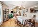 Open-concept dining area featuring hardwood floors, elegant furnishings, and a view of the upper-level balcony at 265 Lee River Cv, Suwanee, GA 30024