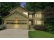 Charming two-story home with lush landscaping, a two-car garage, and a welcoming front entrance at dusk at 265 Lee River Cv, Suwanee, GA 30024