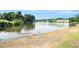 Picturesque pond surrounded by lush trees and a sandy shoreline at 265 Lee River Cv, Suwanee, GA 30024
