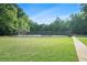 Outdoor tennis courts surrounded by lush greenery and manicured lawn at 265 Lee River Cv, Suwanee, GA 30024