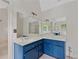Bright bathroom featuring a double sink vanity with blue cabinets and large mirror at 3007 Manning Dr, Marietta, GA 30062