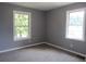 An empty bedroom with gray walls and carpet and two windows providing ample natural light at 3086 Lone Oak Sw Ave, Atlanta, GA 30354