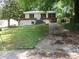 Well-kept one-story home with a grassy front yard, trees, and cracked concrete driveway at 3086 Lone Oak Sw Ave, Atlanta, GA 30354