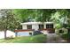 Inviting one-story home with lush trees, manicured lawn, and convenient driveway at 3086 Lone Oak Sw Ave, Atlanta, GA 30354