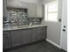 Updated kitchen features gray cabinets, granite counters and stylish mosaic backsplash with a double sink at 3086 Lone Oak Sw Ave, Atlanta, GA 30354