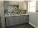 Updated kitchen features gray cabinets, a mosaic tile backsplash, and stainless steel sink and fixtures at 3086 Lone Oak Sw Ave, Atlanta, GA 30354