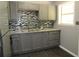 Well-lit kitchen showcasing grey cabinets, stone counters, tile backsplash, and modern appliances at 3086 Lone Oak Sw Ave, Atlanta, GA 30354