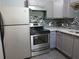 Updated kitchen features stainless steel appliances, gray cabinets, and mosaic tile backsplash at 3086 Lone Oak Sw Ave, Atlanta, GA 30354