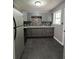 Stylish kitchen featuring sleek gray cabinets, granite counters, modern backsplash, and slate tile flooring at 3086 Lone Oak Sw Ave, Atlanta, GA 30354