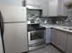 Updated kitchen with grey cabinets, stainless steel appliances, and a stylish mosaic backsplash at 3086 Lone Oak Sw Ave, Atlanta, GA 30354