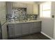 Updated kitchen features gray cabinets, granite counters and stylish mosaic backsplash at 3086 Lone Oak Sw Ave, Atlanta, GA 30354